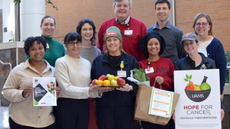 Ten people representing the UAMS Fay W. Boozman College of Public Health’s Center for the Study of Obesity pose with produce and signage promoting “Hope for Cancer: Healthy Outcomes Through Produce Prescriptions and Education.”
