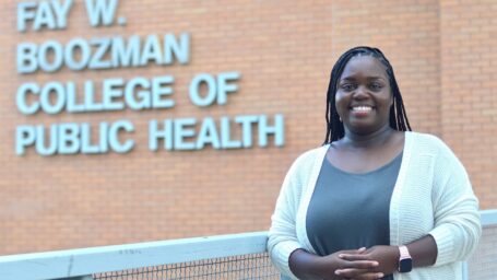 female student standing in front of the college of public health